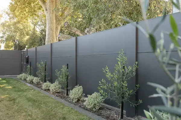 Installazione di barriere antirumore in un giardino privato per ridurre il rumore del traffico e migliorare il comfort acustico
